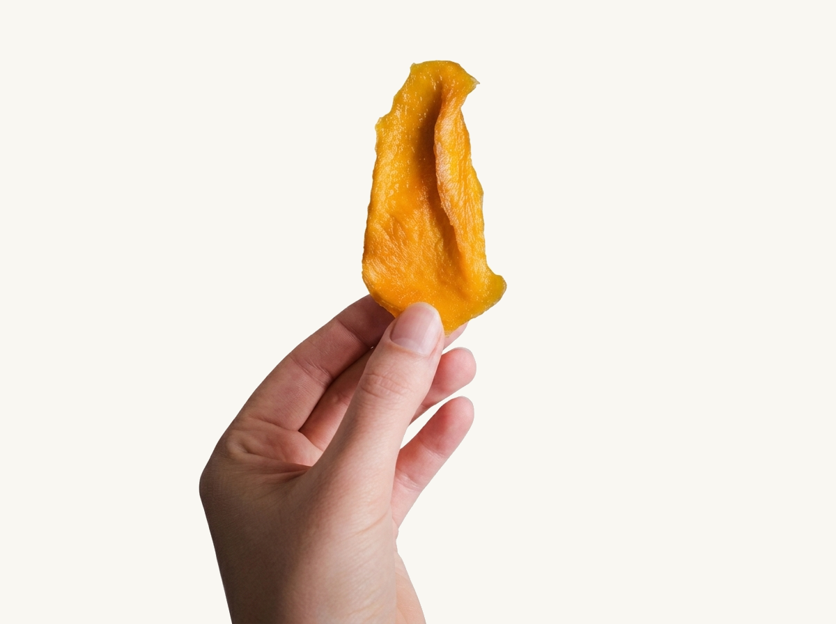 Mangoscheibe in der Hand