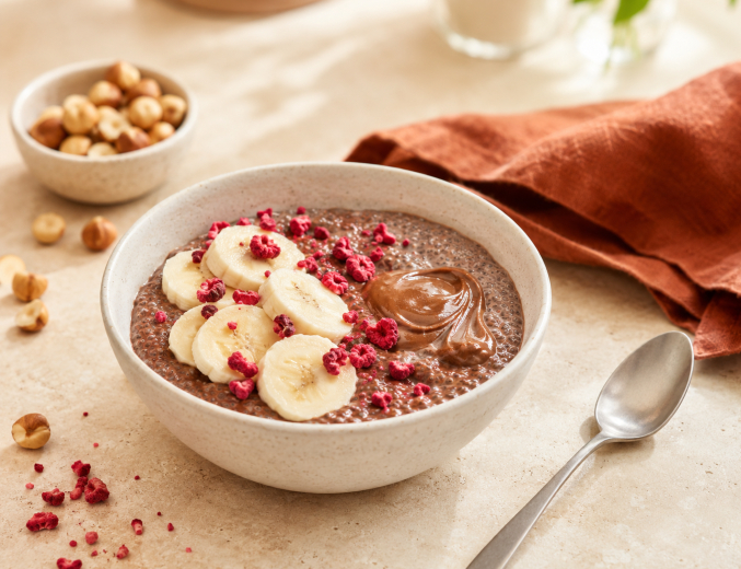 Schokoladen-Chia-Pudding mit Banane, Haselnusscreme und gefriergetrockneten Himbeeren.