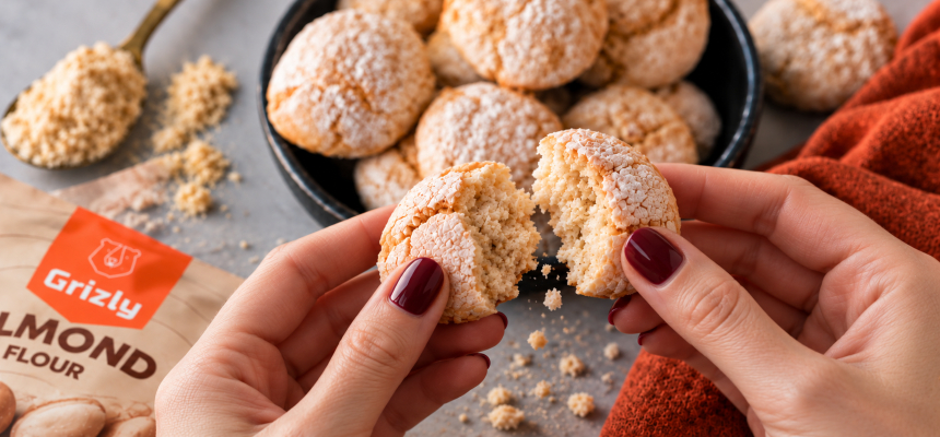 Frauenhände, die einen Amaretti-Keks zerbrechen